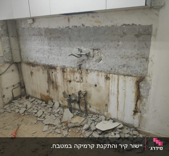 קיר חשוף עם צנרת, הריסות בטון על הרצפה